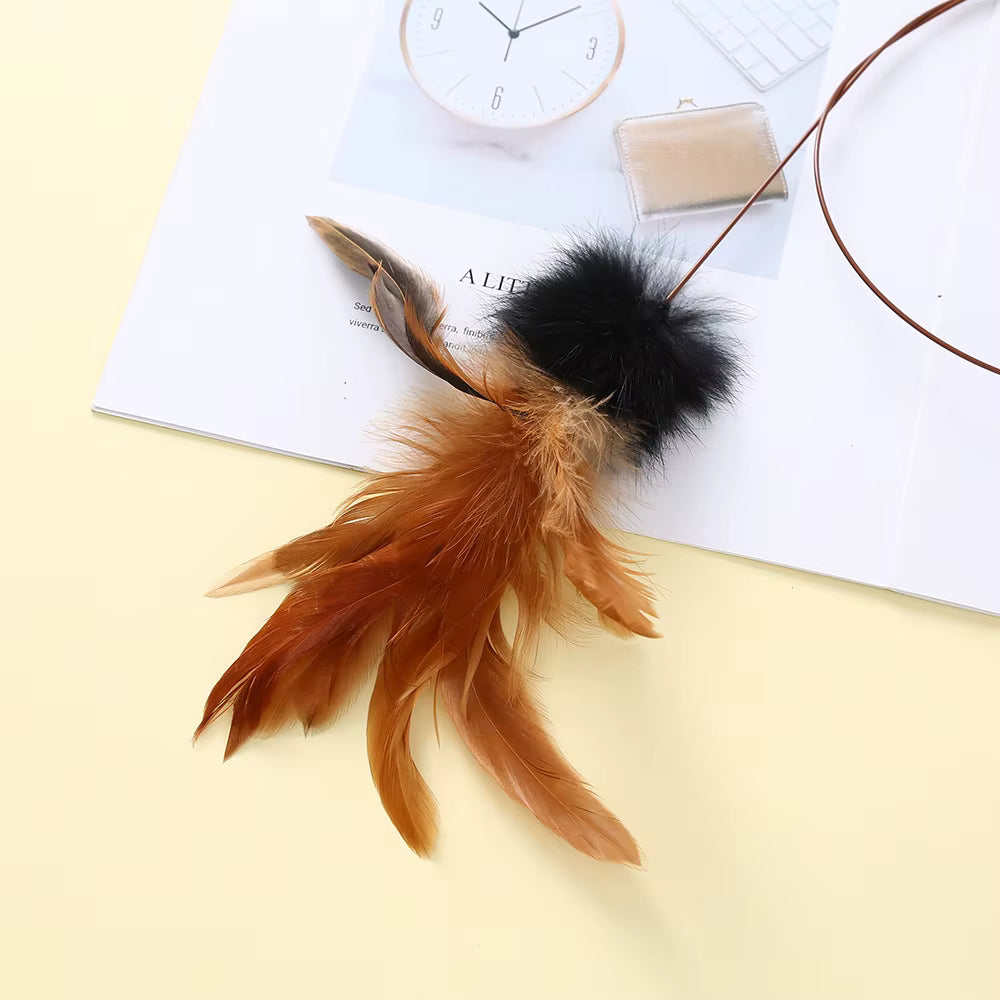 Feather keychain with black pom-pom on a magazine with a clock in the background