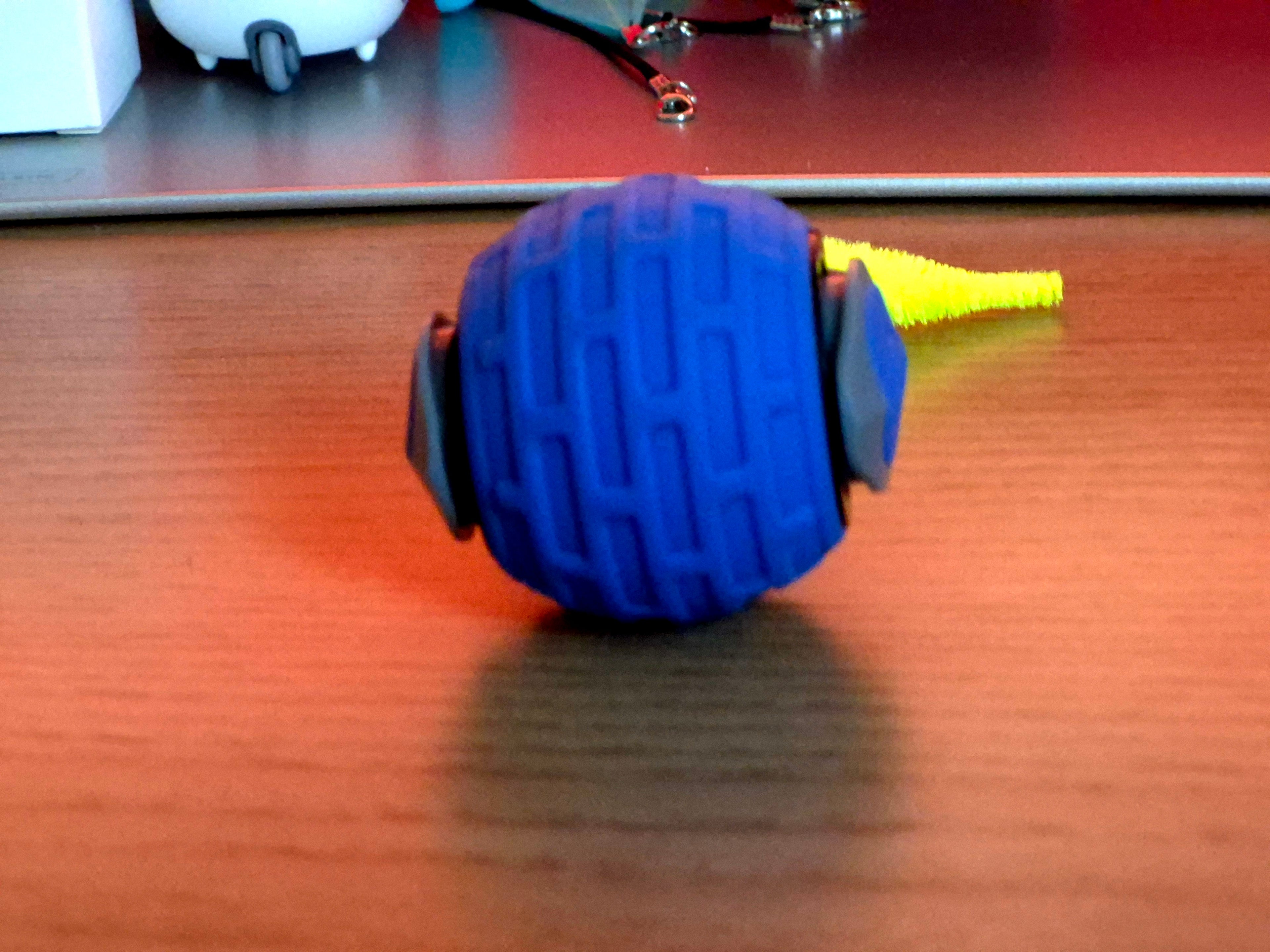 Blue massage roller ball on a wooden surface with blurred background