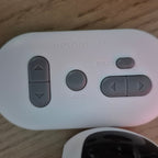 White remote control with gray buttons on a wooden surface