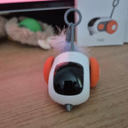Small electronic device with orange accents on a wooden surface