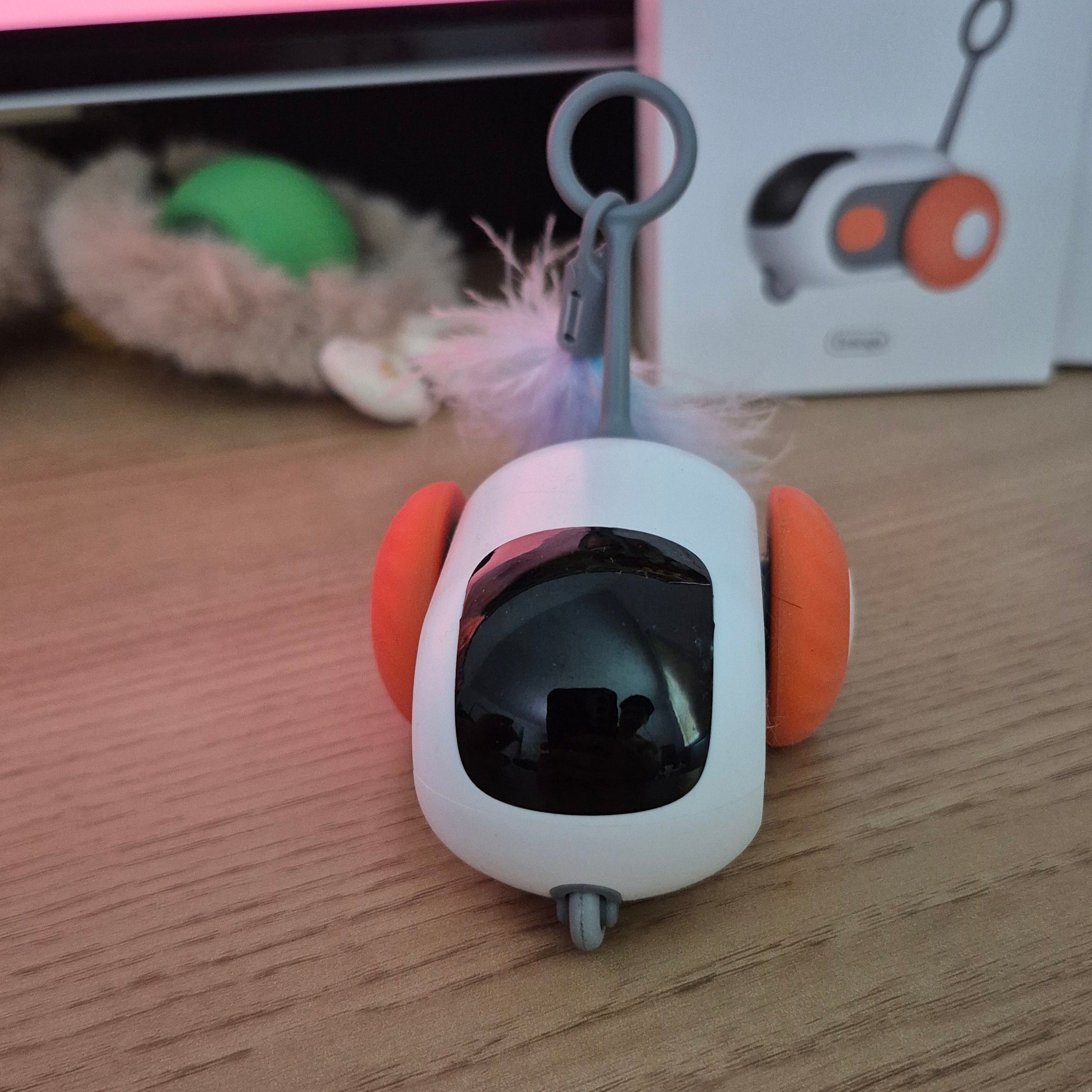 Small electronic device with orange accents on a wooden surface